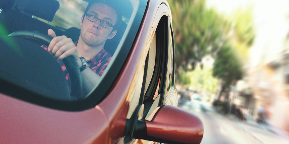 Man in a red car driving